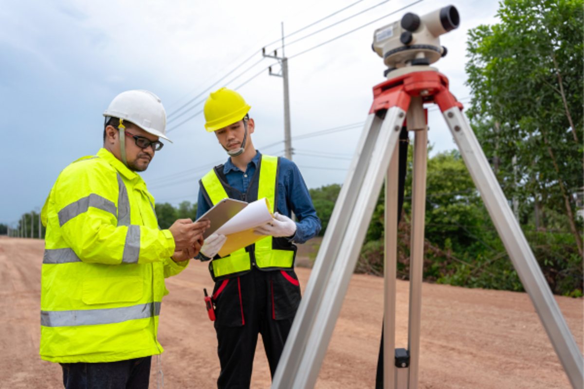 A professional conducting a survey of the construction site